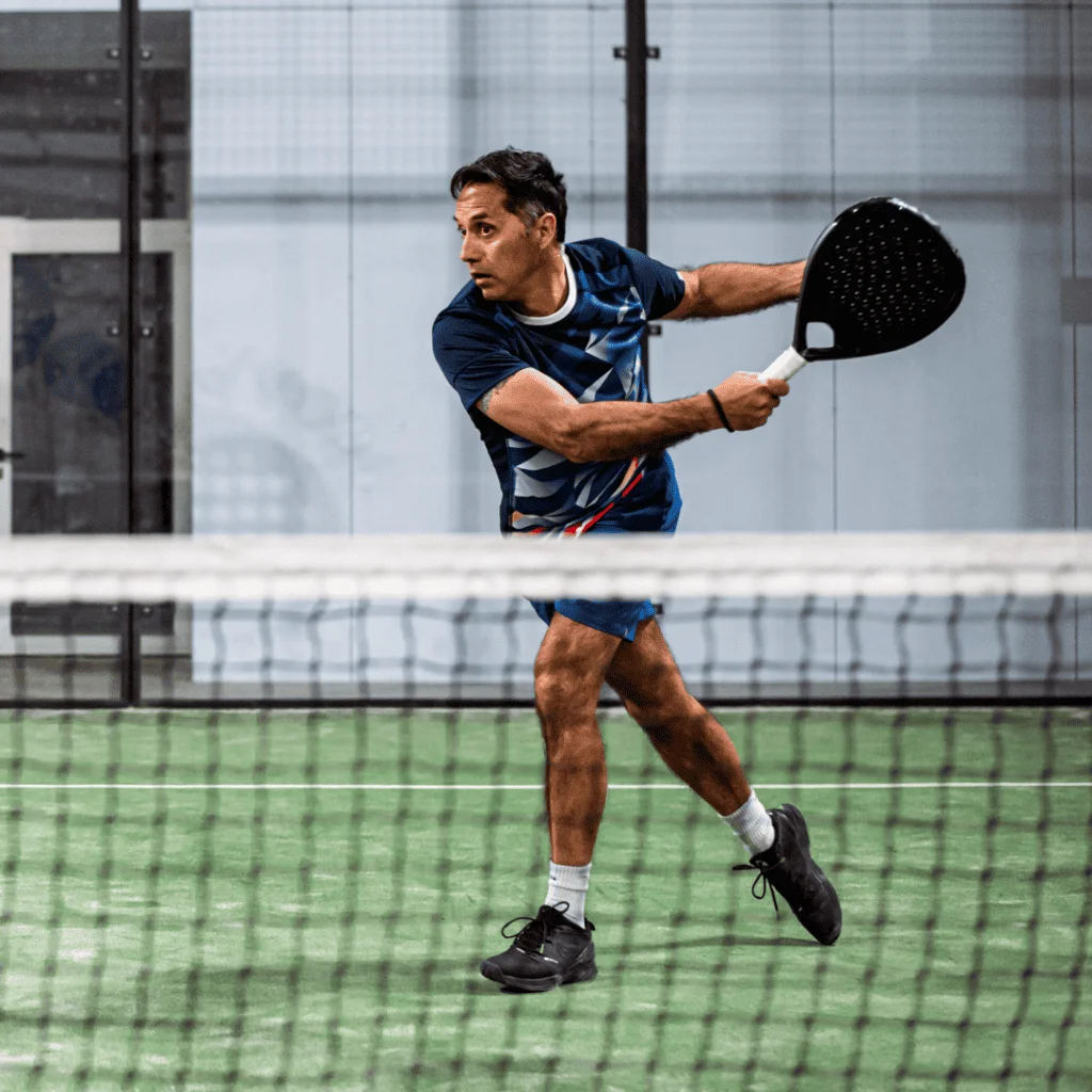 Male padel player on a green padel court